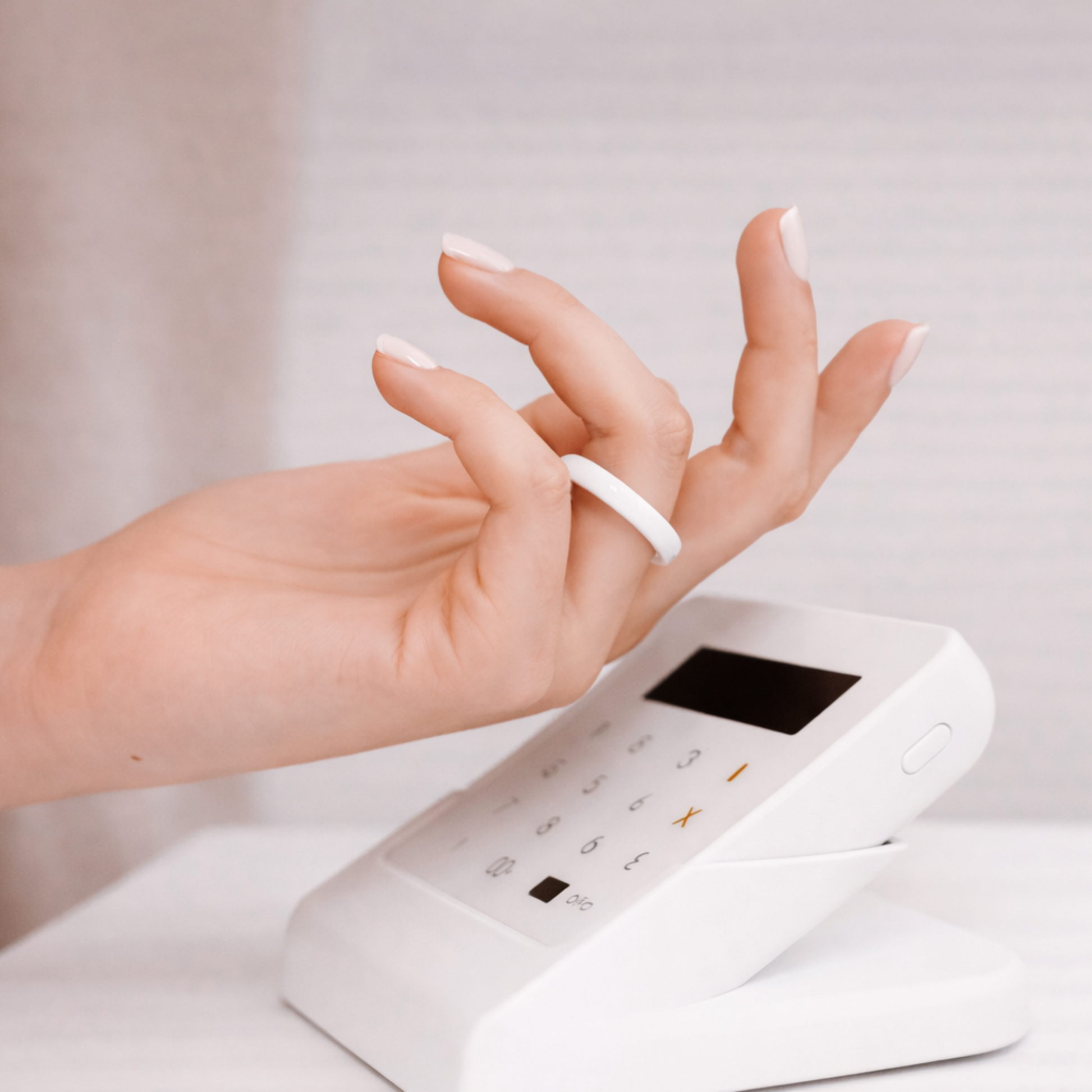 Person paying with Twinn Ultra White ceramic contactless payment ring
